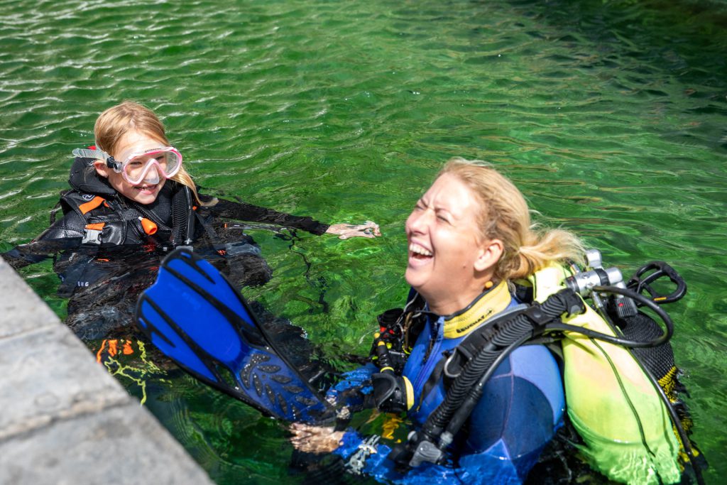 Flossen anziehen im Übungspool für den IAC Junior Scuba Diver