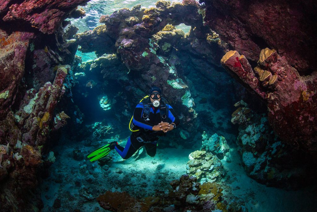 Taucher in lichtdurchfluteter Grotte, Tauchplatz Dolphin House, Tauchbasis Euro-Divers, Utopia Beach Club, Ägypten, El Quseir